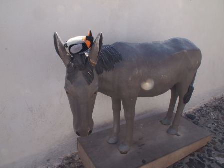penguin sitting on donkey statue