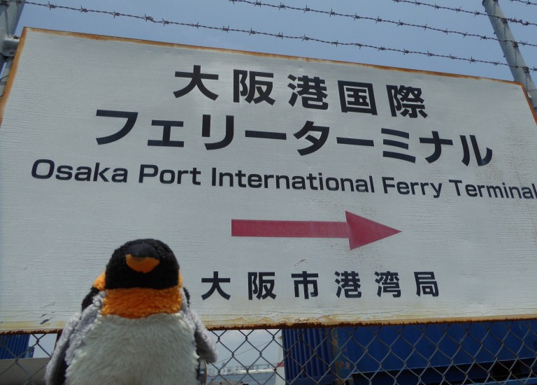 penguin in front of Osaka port sign