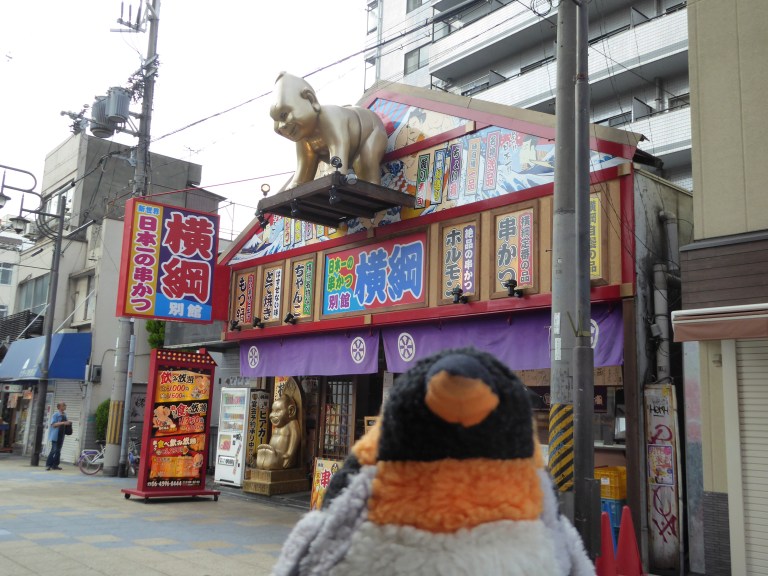 penguin in front of sumo sign